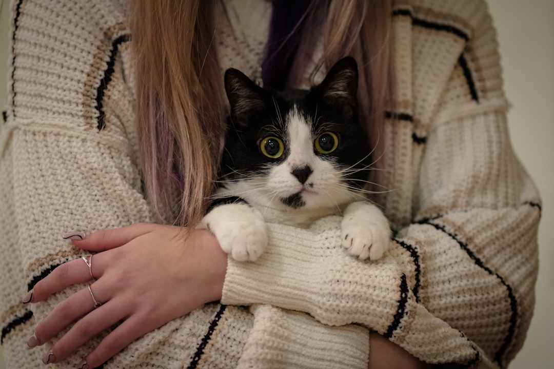pet portrait - a woman holding a black and white cat in her arms